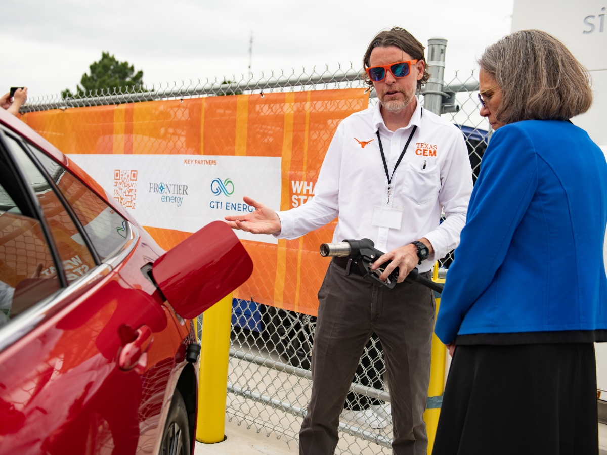 UT Provost Sharon Wood and Michael Lewis from the Center for Electromechanics talking in front of Toyota Mirai