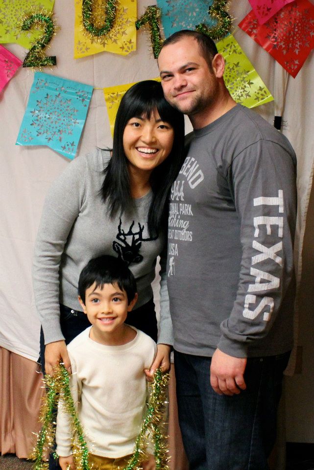 Schaefferkoetter family smiling in front of multi-colored celebration banner