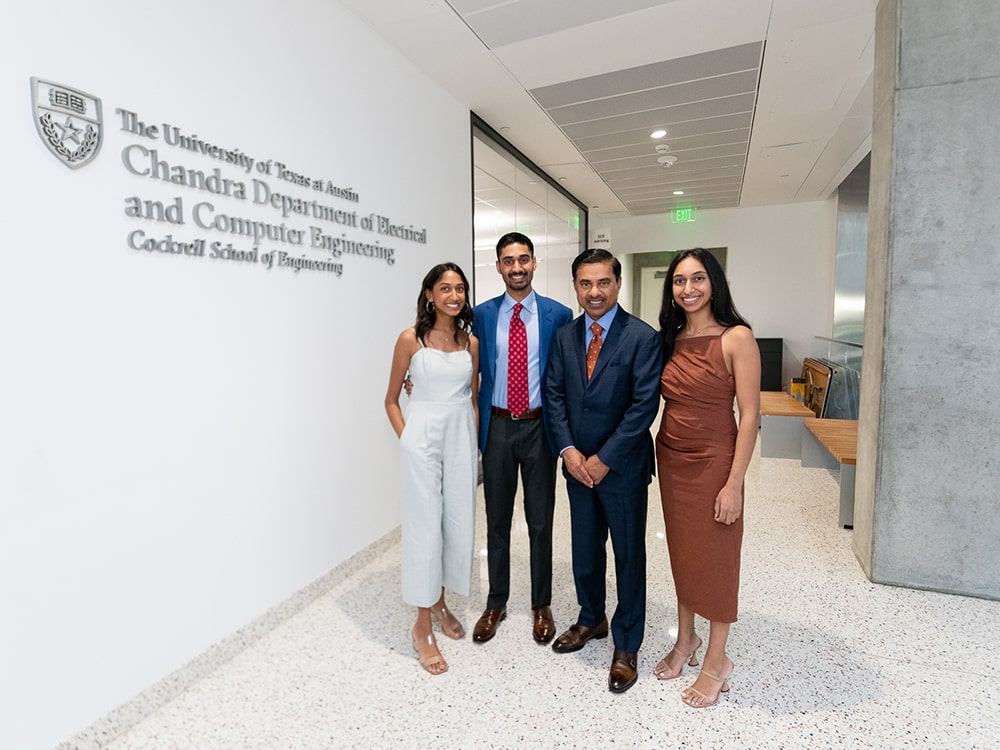 The Chandra family smiling next to the new building engraving for Chandra Family Department of Electrical and Computer Engineering