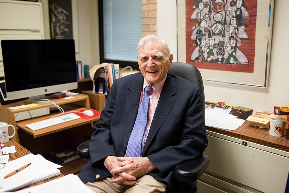 Goodenough sitting at desk in office