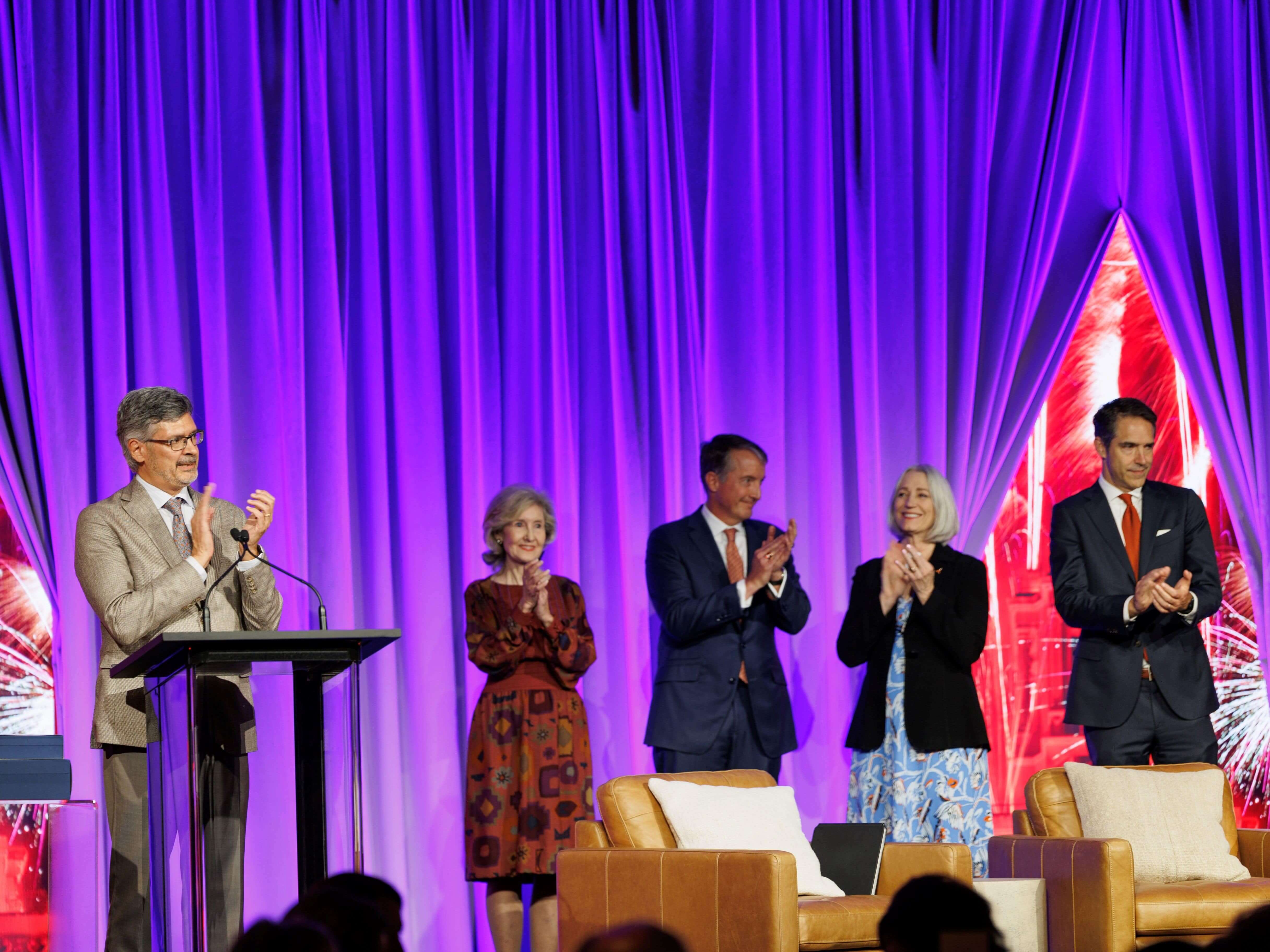 Roger Bonnecaze, Jay Hartzell and other UT Austin leadership applauding on stage