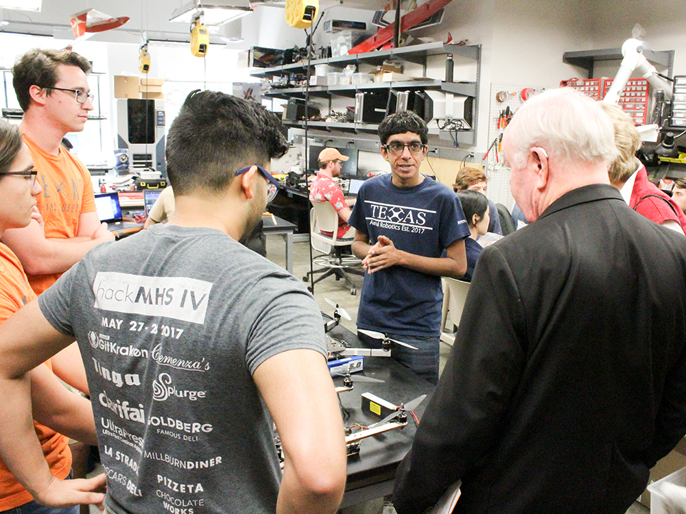 A crowd of people gathered around engineering equipment