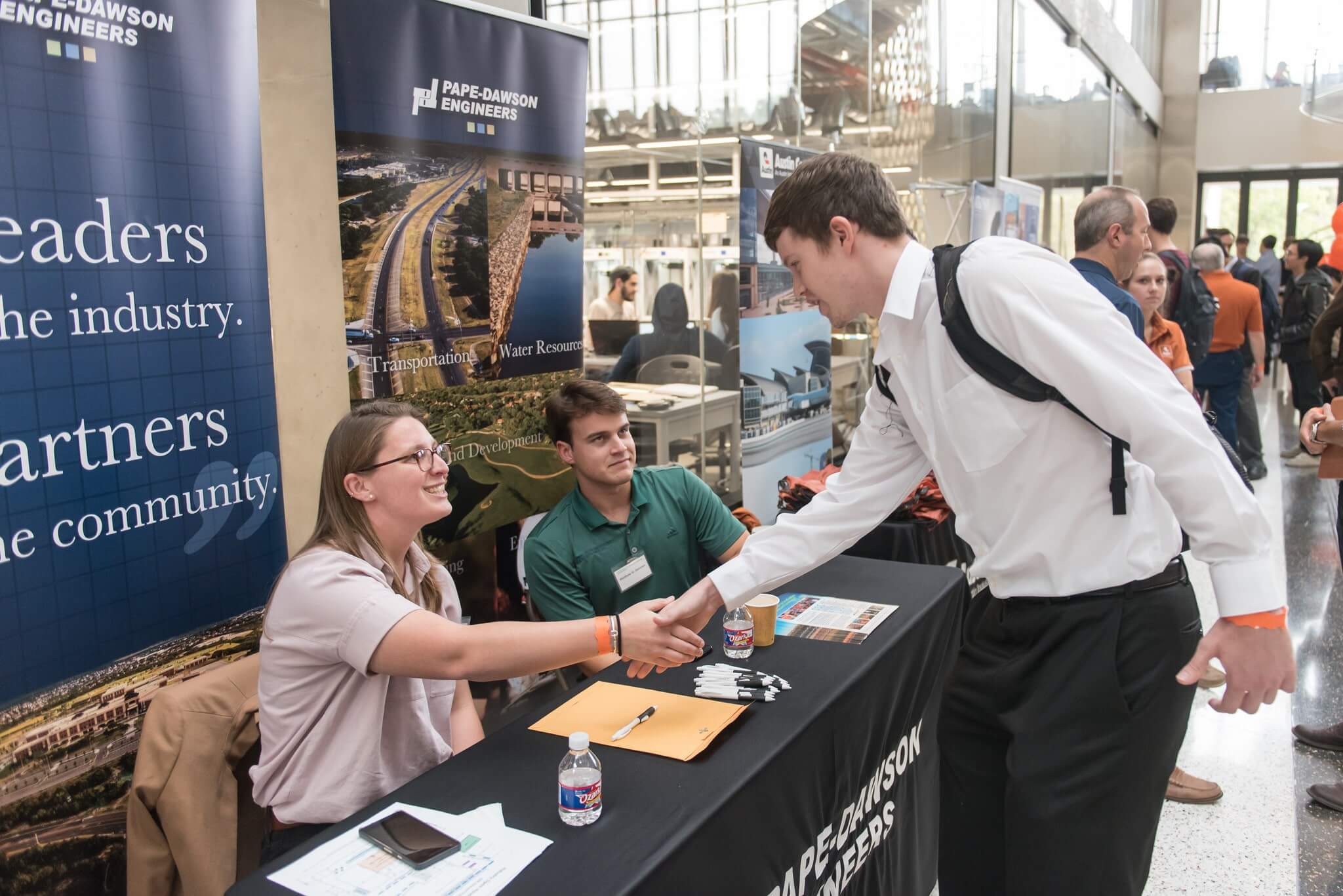 Texas Engineering student shaking hands with industry representatives at an industry open house event