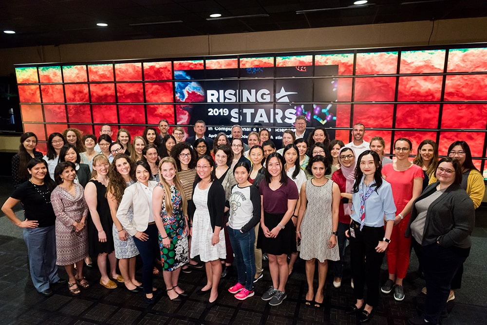 Rising Stars group smiling in front of Rising Stars digital screens