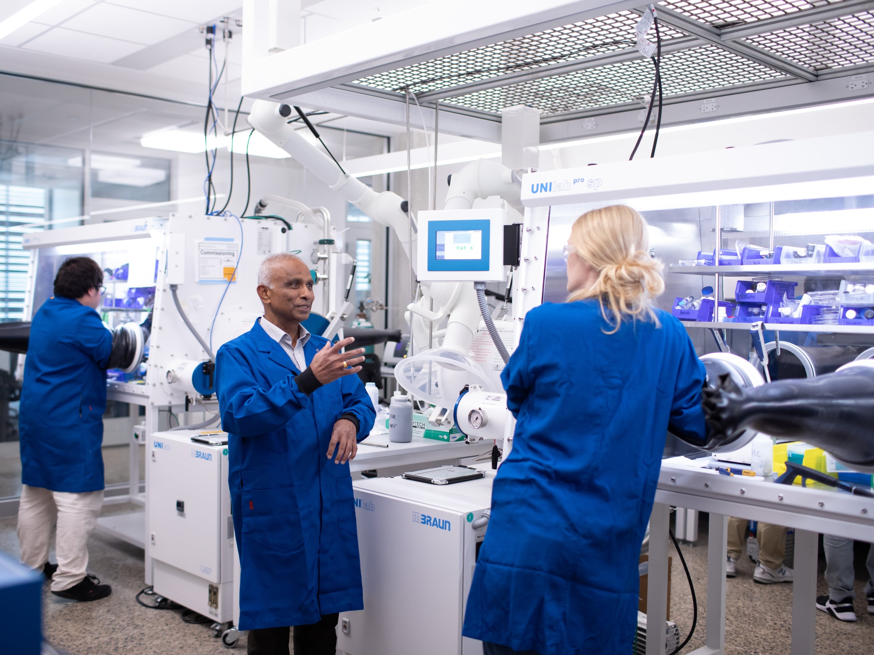 Mechanical engineering professor Arumugam Manthiram talks to students at his battery lab in the Gary L. Thomas building at The University of Texas at Austin