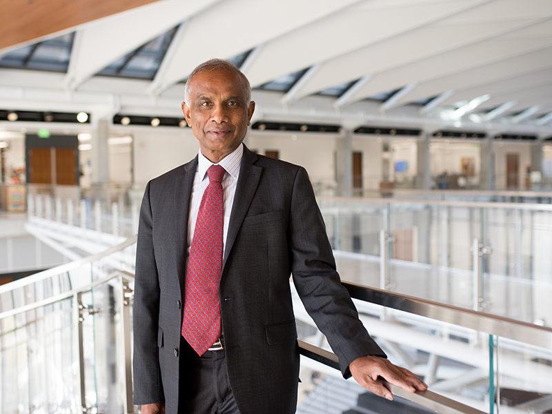 Portrait of Arumugam Manthiram at the top of the spiral staircase inside of the Engineering Education and Research Center.