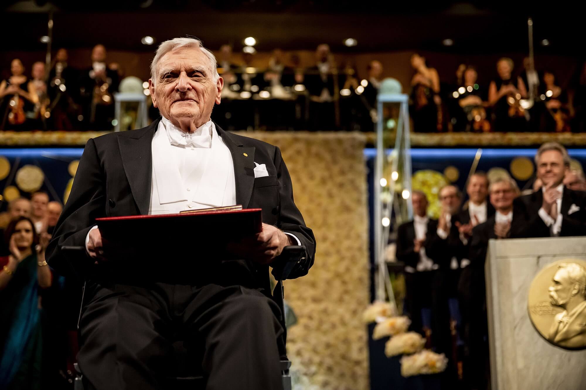 John Goodenough receiving the Nobel Prize with cheering crowd behind him