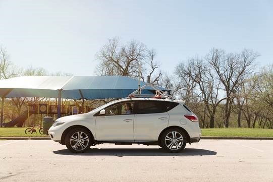 SUV parked beside playground with device strapped to the roof