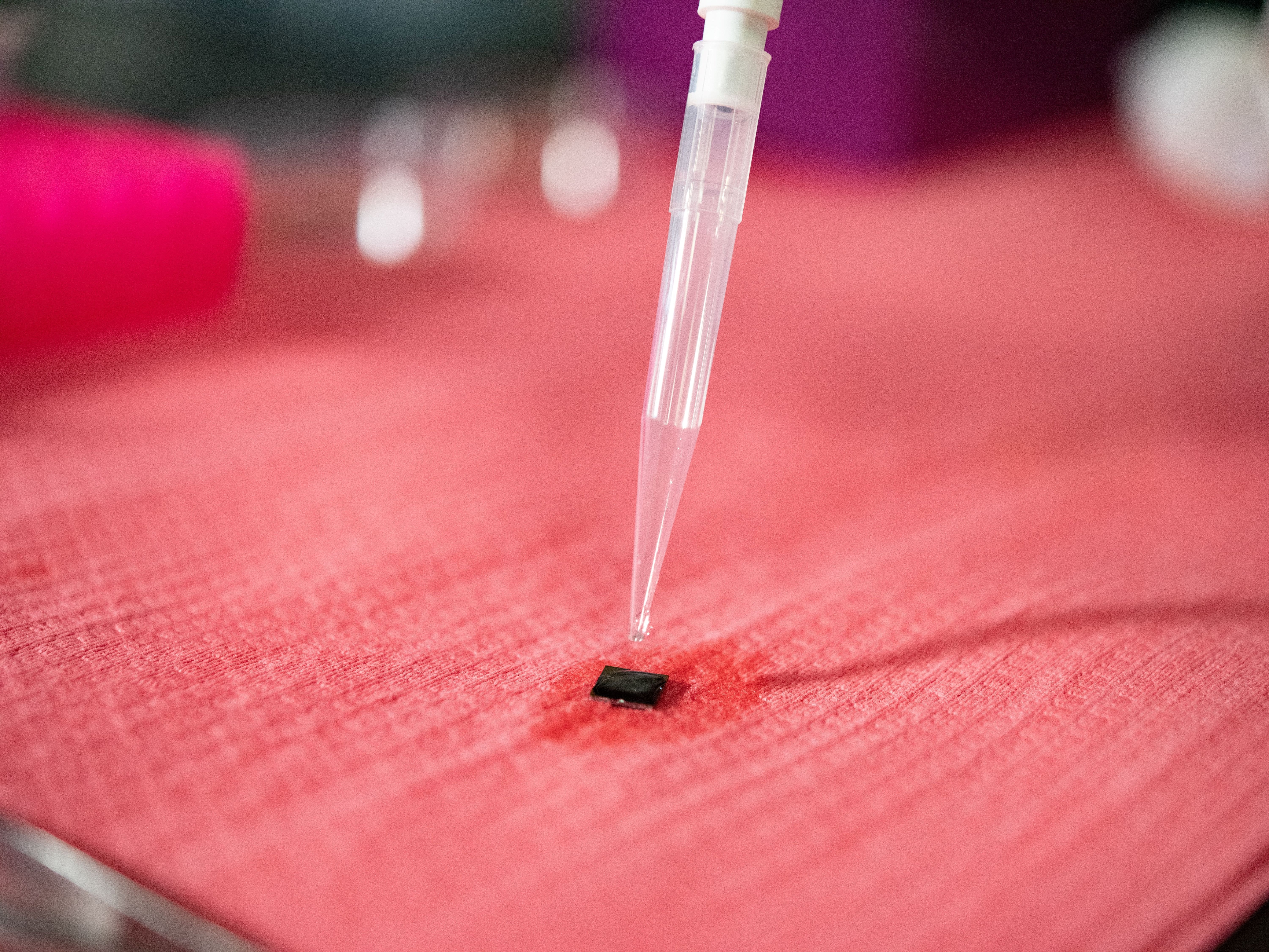 Water dropper dripping liquid onto small square material
