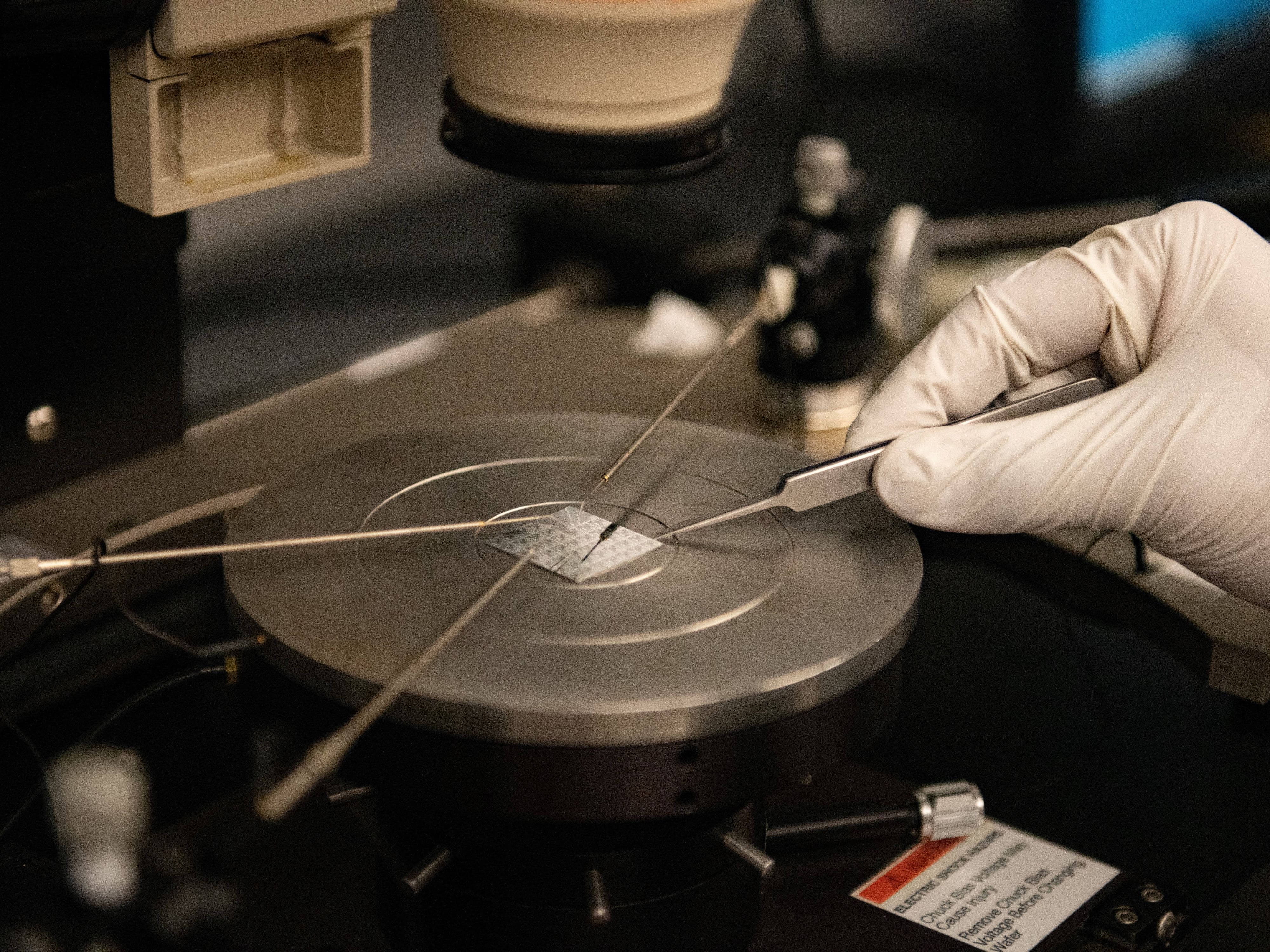 Gloved hand using sharp tools on semiconductor part
