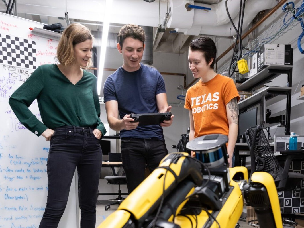 Texas Engineering students looking at a robot