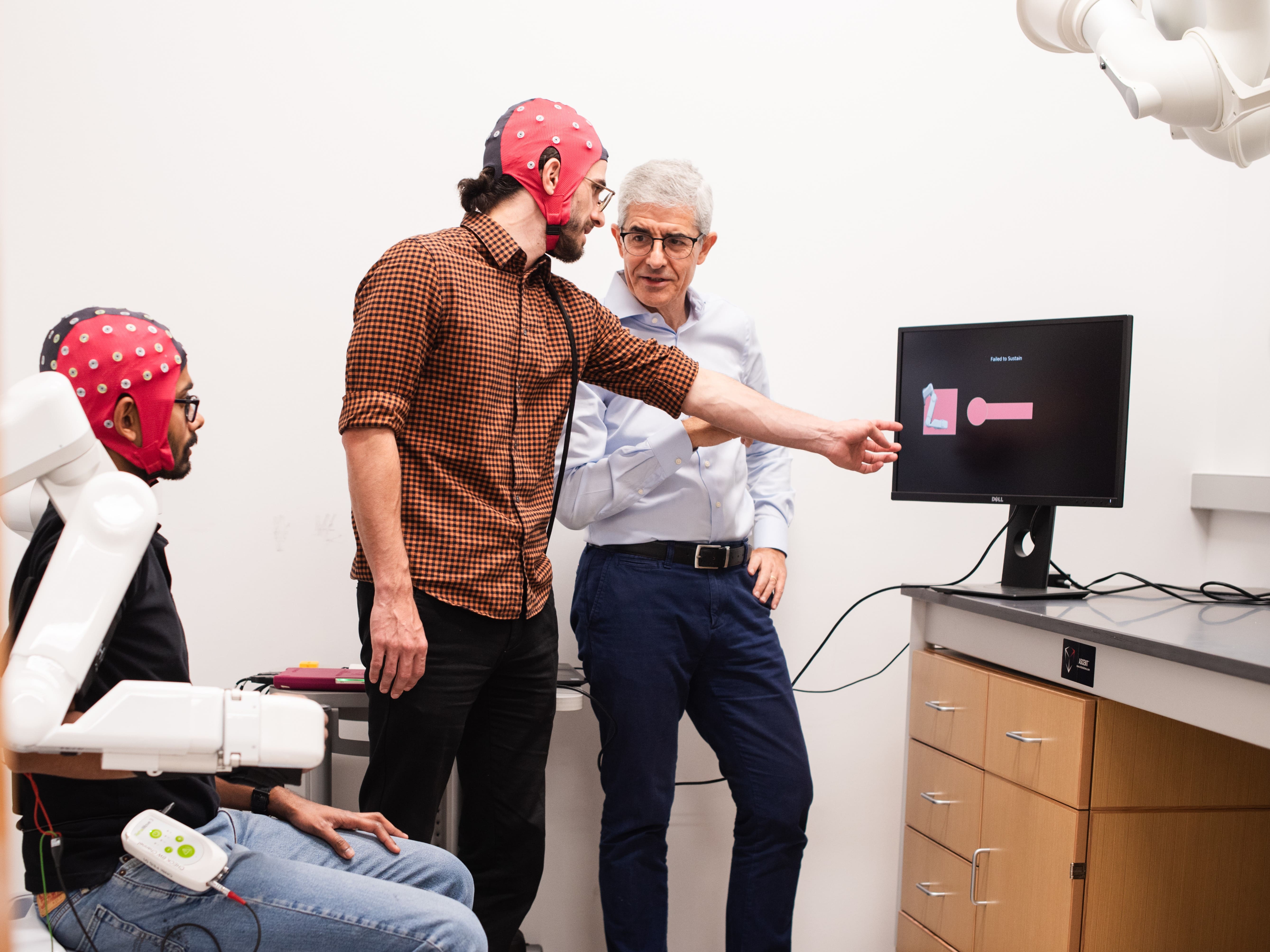 Texas engineers wearing electrode caps with Professor Jose Millan