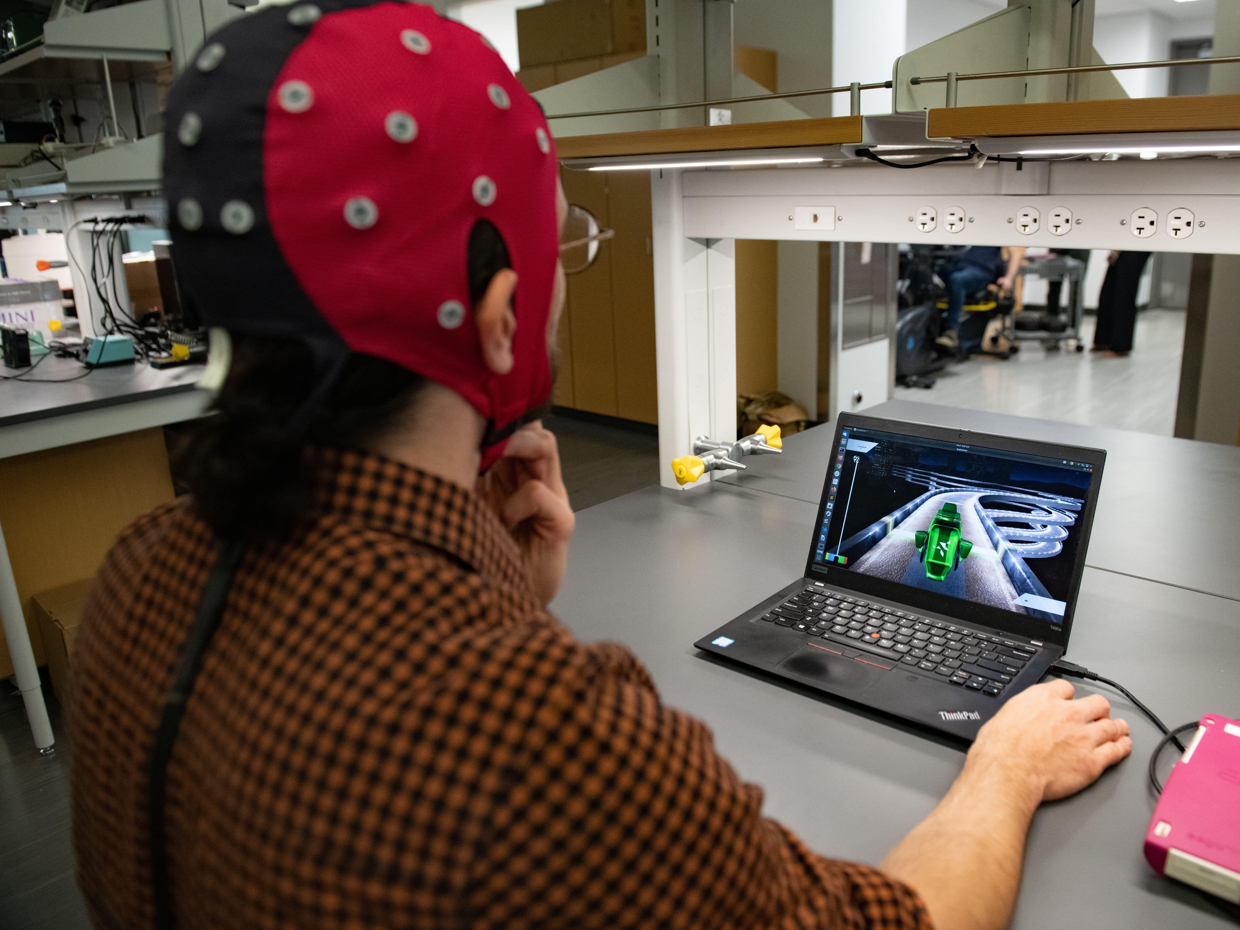 Texas Engineering student wearing electrode cap at computer desk