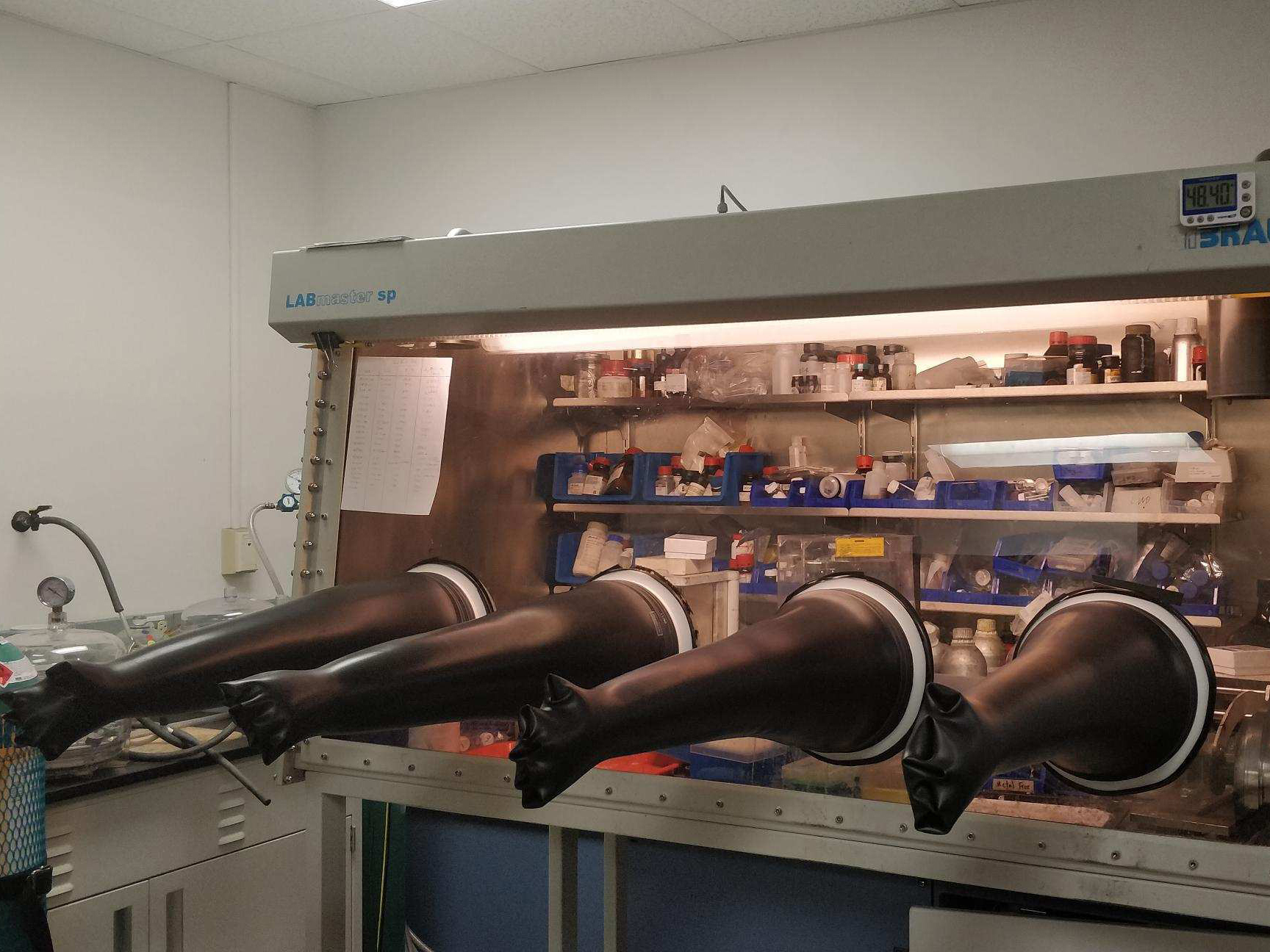 glass case of lab equipment wih rubber glove attachments
