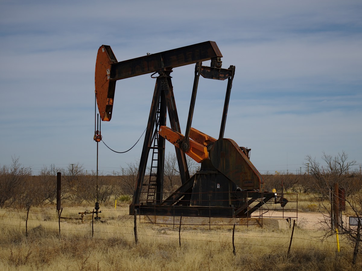 A black and red pumping unit in a West Texas oil field