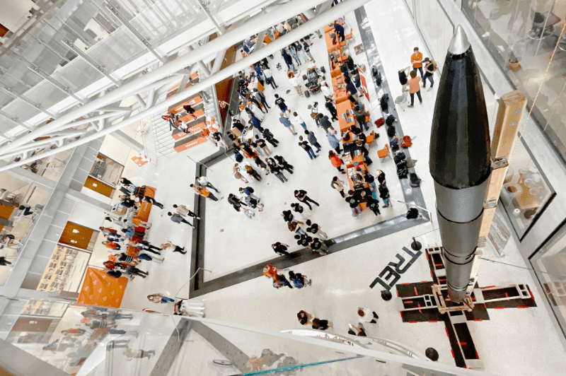 TREL rocket in EER building with Texas engineering students walking around
