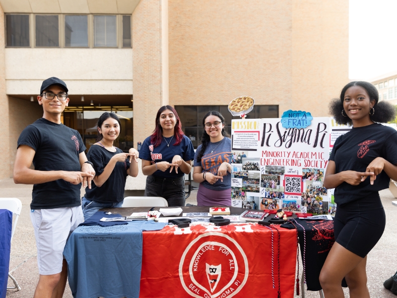Texas engineering students in front of Pi Sigma Pi booth