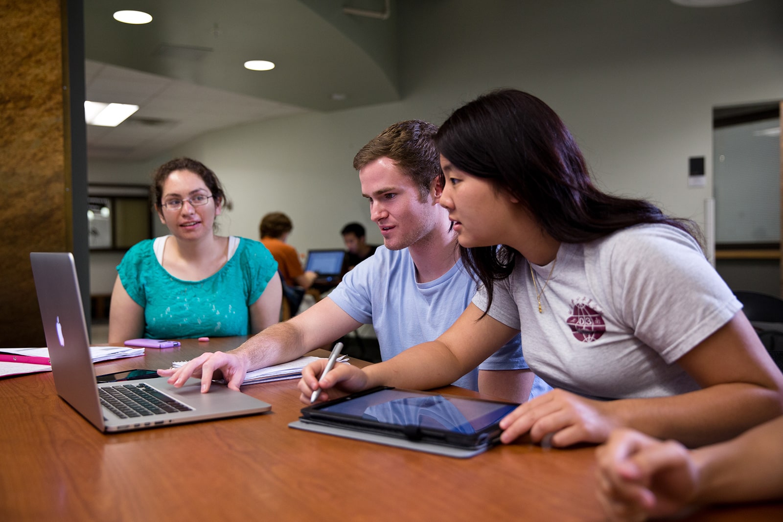 three Texas engineering students working together on a computer and tablet
